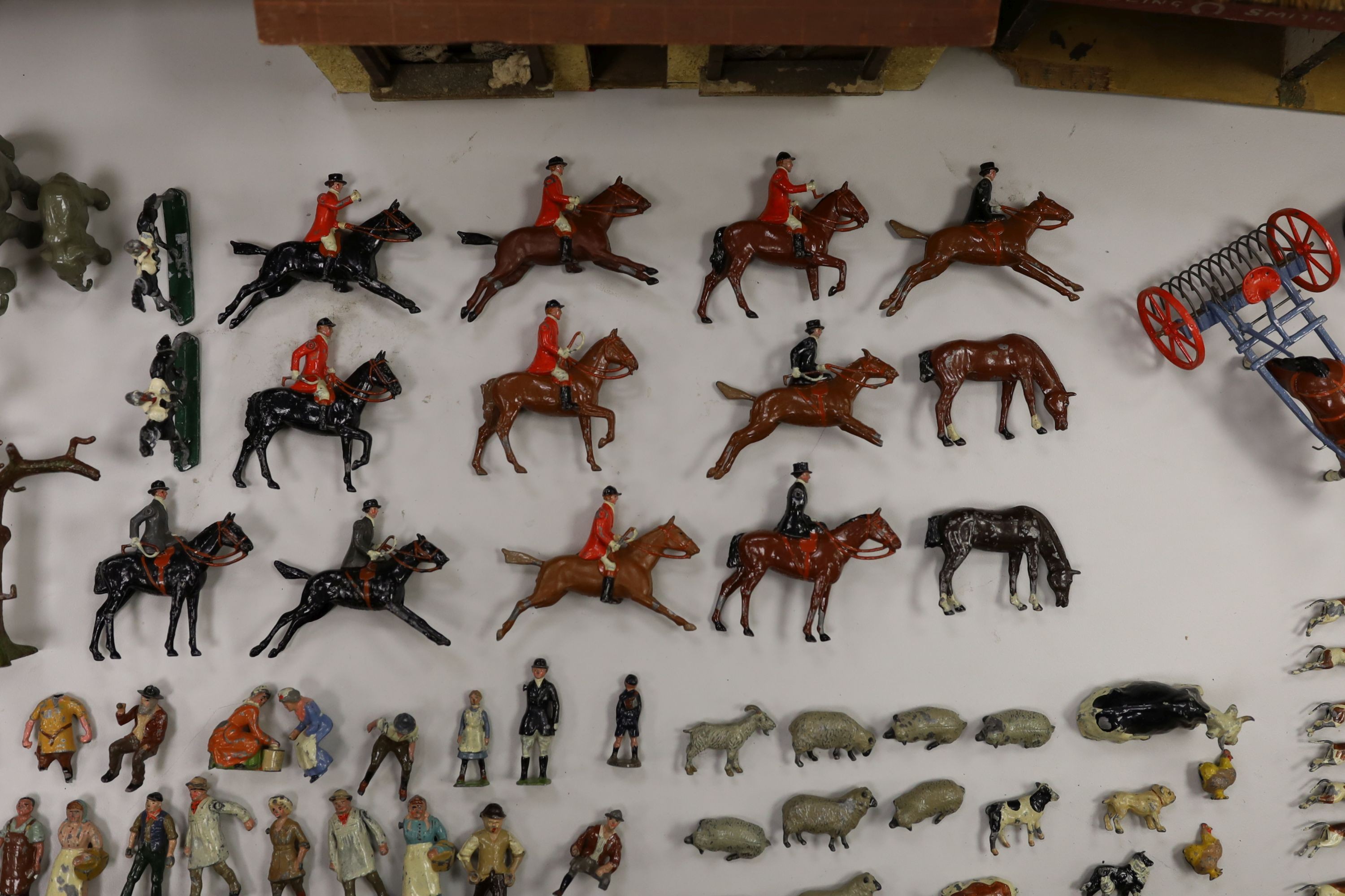 A collection of mainly Britains painted lead figures and animals, including huntsmen and hounds, farm workers, animals and wooden buildings